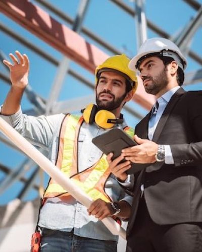 Free Photo _ Civil engineer and construction worker manager holding digital tablet and blueprints talking and planing about construction site cooperation teamwork concept