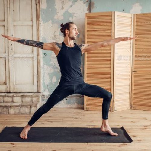 Male yoga doing stretching exercise on mat